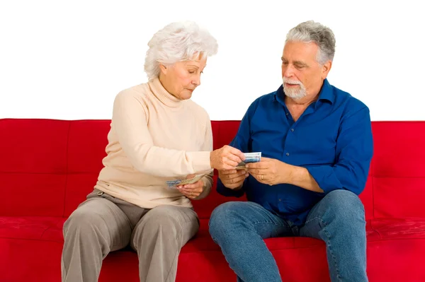 Coppia anziana sul divano con i soldi in mano — Foto Stock