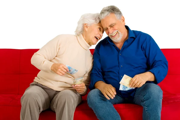 老人夫妇在沙发上用的钱在手 — 图库照片