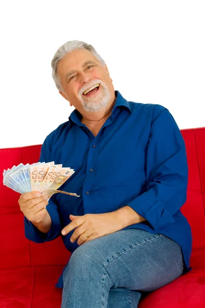 Elderly man on the couch with money in hand — Stock Photo, Image