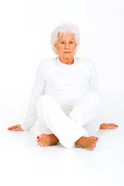 Пожилая женщина сидит на полу — стоковое фото