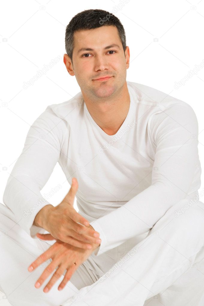 Man dressed in white sitting on the floor