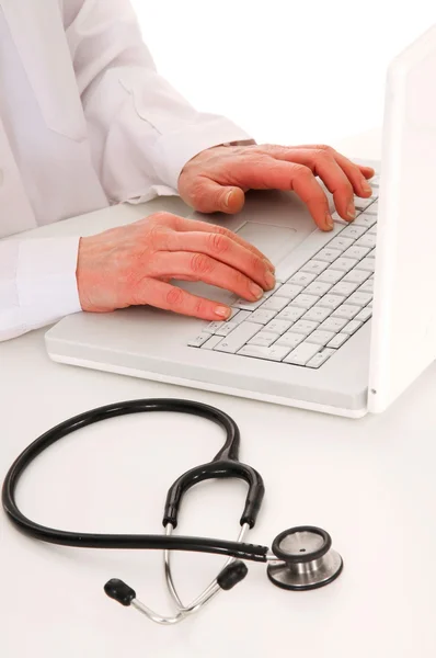 Läkare vid skrivbordet med stetoskop — Stockfoto
