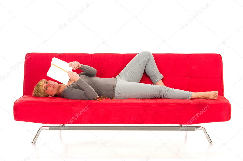 Woman lying on the couch reading a book