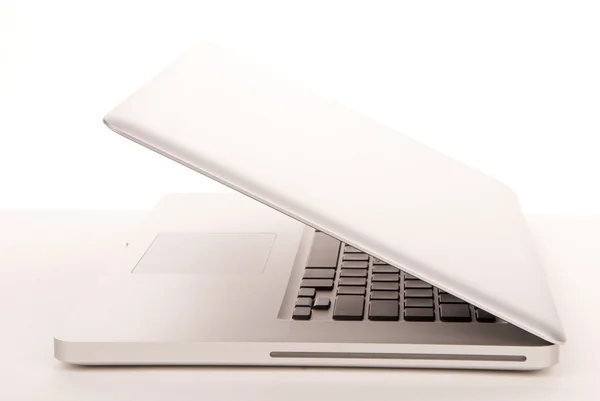 モダンでスタイリッシュなキーボード タッチパッド 白い背景の上の Dvd が付いている側面から開かれたラップトップ コンピューター — ストック写真