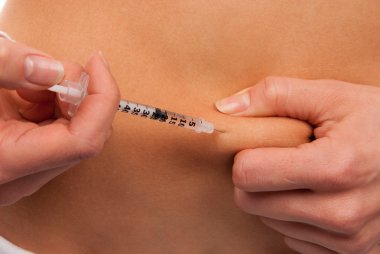 Diabetes injecting insulin syringe shot by single use small needle with dose of lantus 2 inches away from belly button isolated on a white background clipart