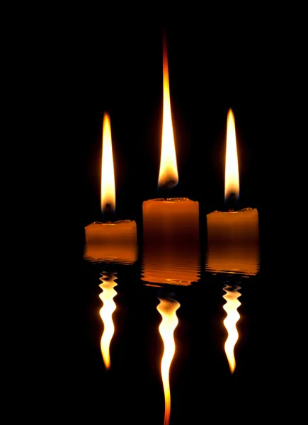 三个白色的蜡烛燃烧和在夜里在清澈的水中反映了 — 图库照片