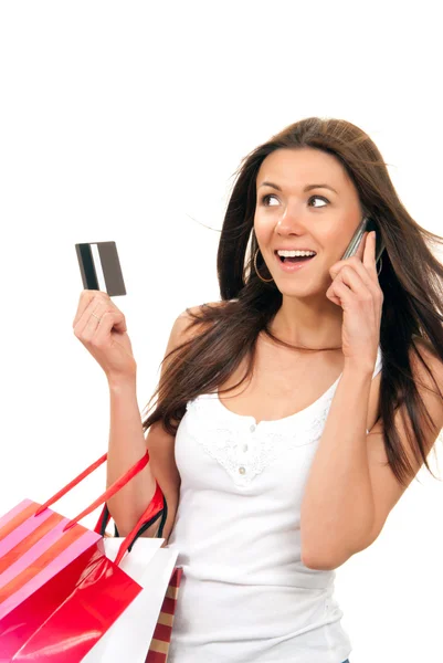 Жінка торгує сумками та кредитною карткою, розмовляючи по телефону — стокове фото