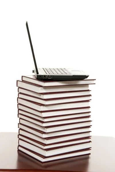 Черный новый ноутбук на стопке книг — стоковое фото