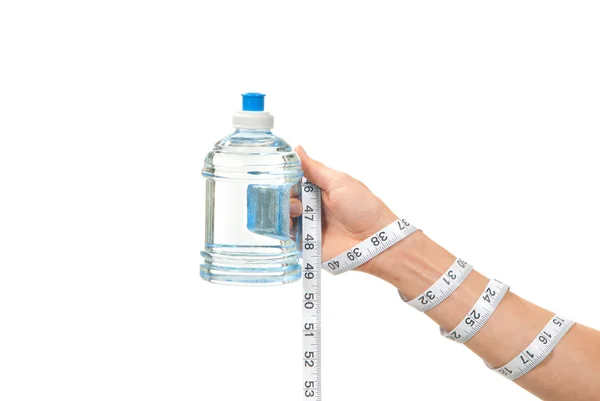 Tape measure is twisted around hand with bottle of water — Stock Photo, Image