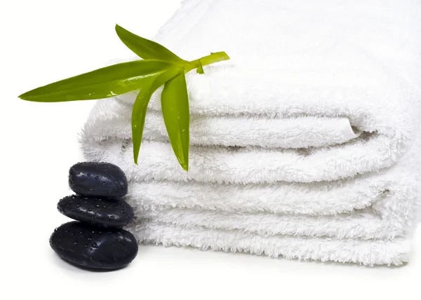 Towels, black pebbles and plants. — Stock Photo, Image