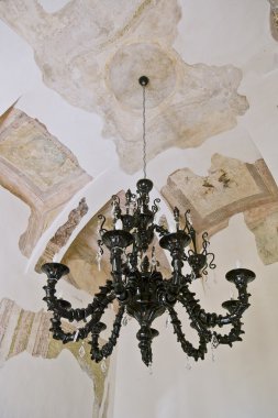 ancient black glass l chandelier with black portions of the restored frescoes on the ceiling clipart