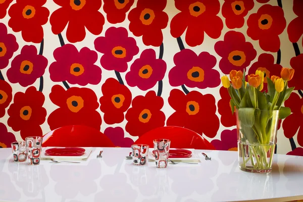 テーブルの上のチューリップと背景に描かれた花の花瓶 — ストック写真