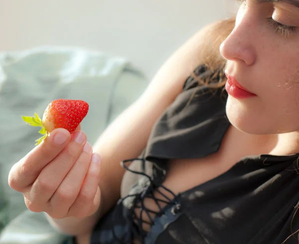 年轻美女与多汁的红草莓 免版税图库图片