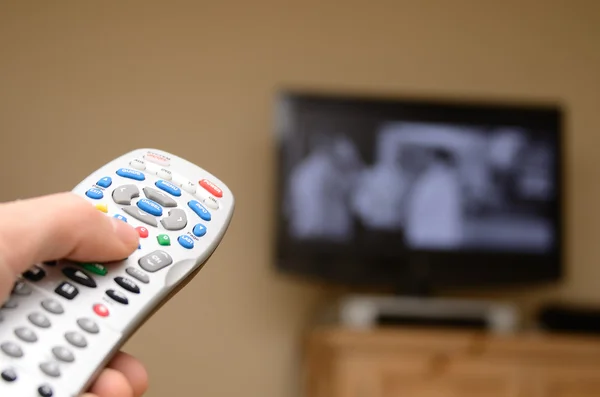 stock image TTelevision remote in the foreground with selective focus and television in the background.