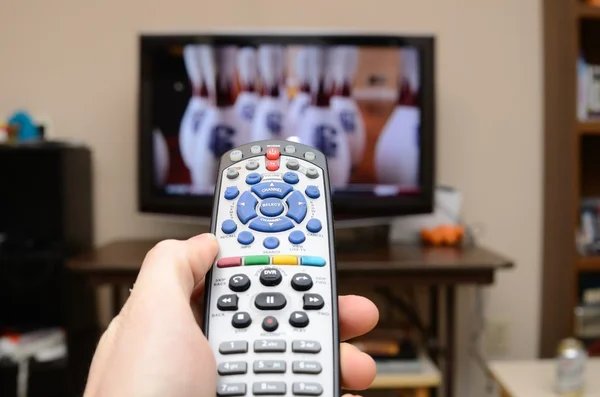 stock image TTelevision remote in the foreground with selective focus and television in the background.