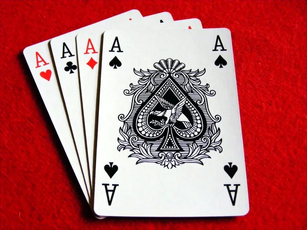 4 aces playing cards on red felt table