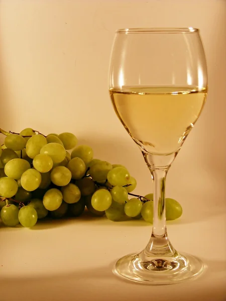 stock image Glass of white wine and grapes