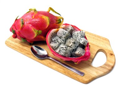 Diced dragon fruit pieces on a wooden chopping board clipart