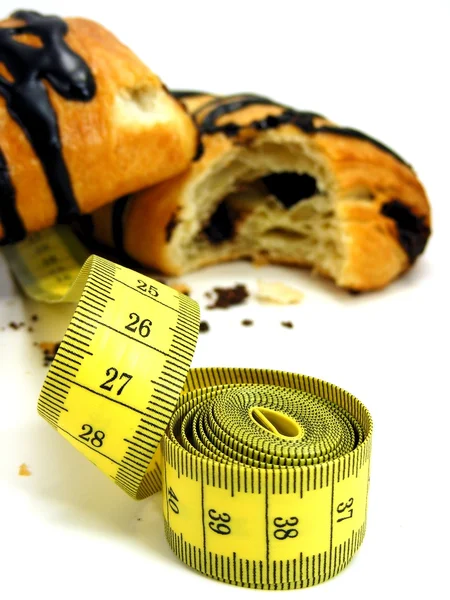 Chocolate pastry cakes & measuring tape — Stock Photo, Image