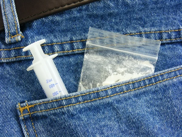 Drugs & hypodermic needle in back pocket — Stock Photo, Image
