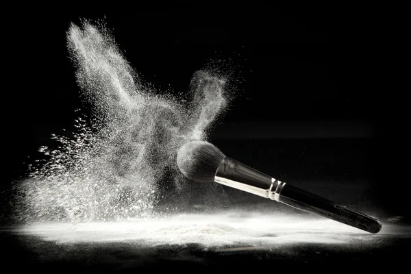 A composition with a powder brush and white loose powder — Stock Image A composition with a powder brush and white loose powder Stock Image