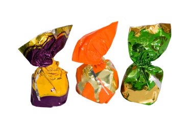 Three chocolates in a colored shiny packaging. white background. clipart