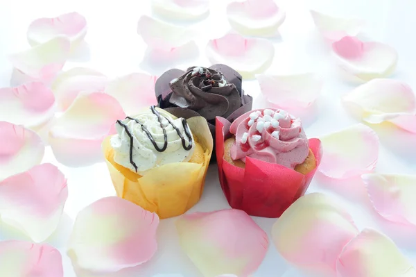 Drei Farbige Muffins Auf Einem Teppich Aus Rosenblättern — Stockfoto