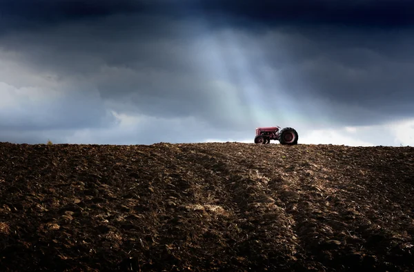 Трактор на вспаханном поле — стоковое фото