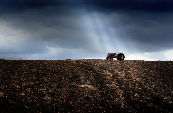 Tractor en el campo arado Imagen de archivo