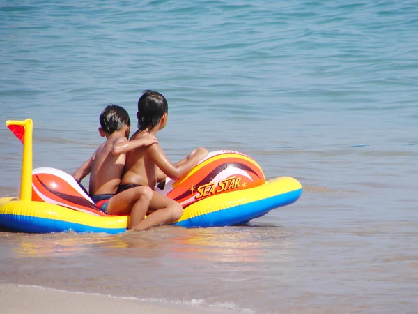 Kids, inflatable boat and ocean