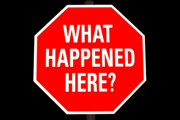 Segnale di stop con "Che cosa è successo qui" su di esso isolato su nero Immagine Stock