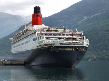 Norveç Fiyordu içinde küçük bir liman içinde büyük yolcu gemisi.