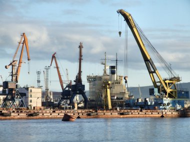 Large and busy sea port in Murmansk, Russia. clipart