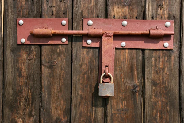 Old padlock on wooden door — Stock Photo, Image