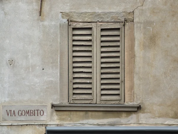 Old window and street name in Italy. Building in Bergamo, Lombardy. Mediterranean architecture.
