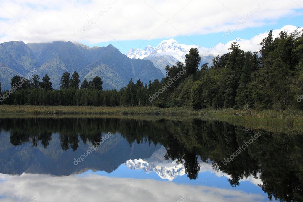 New Zealand. Lake Matheson - famous view with reflection of snowy Mount Tasman and Mount Cook. Westland district.
