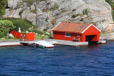 Norway - Skjernoy island in the region of Vest-Agder. Red fishing boat garage. clipart
