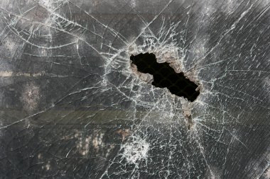Broken window of armoured glass. Bulletproof glass hole. clipart