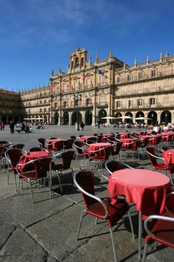 Cafe tables at Plaza Mayor - main city square in Salamanca, Castilla y Leon, Spain. Many tourists and local walking and sitting around. clipart
