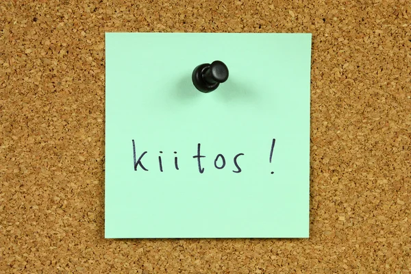 绿色粘滞便笺固定到办公室公告板 Kiitos 谢谢你在芬兰语语言 — 图库照片