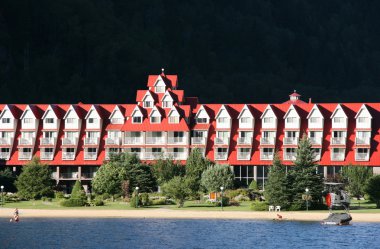 Göl üzerinde kırmızı çatı ile güzel bir otel. Holiday resort. Üç vadi lake chateau.