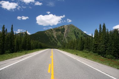 Straight road in Rocky Mountains. Highwood Trail - Kananaskis Country, Alberta, Canada. clipart