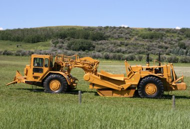 Heavy duty scraper - earth moving machine in Canada. Wheel tractor-scraper. clipart