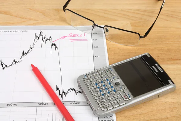 株式市場ろうそく足グラフ 赤いマーカー メガネとモバイルのスマート フォンの発言 — ストック写真