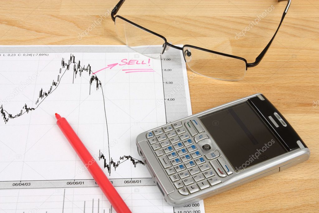 Stock market candle charts, remarks with a red marker, glasses and mobile smart phone