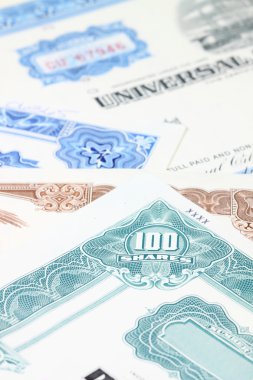 Stock market collectibles. Old stock share certificates from 1950s-1970s (United States). Vintage scripophily objects (obsolete) with shallow depth of field (fo clipart