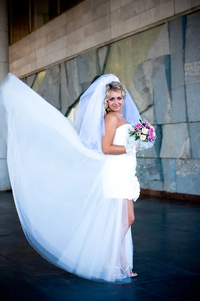 A noiva em um vestido de casamento branco com um buquê Imagem De Stock