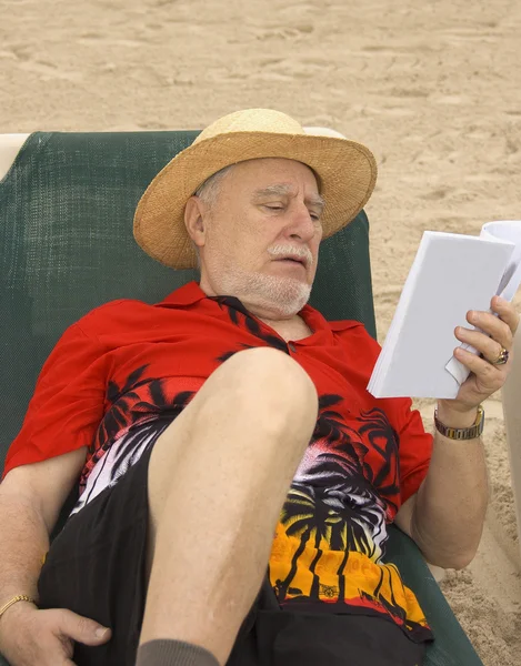 Старший читатель на пляже — стоковое фото