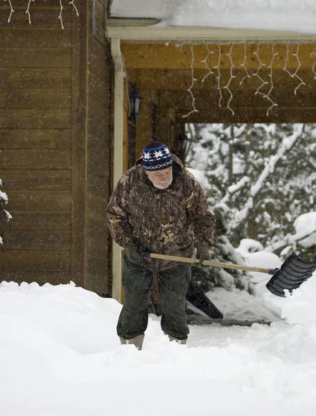 Senior shovelling snow — Stock Photo, Image