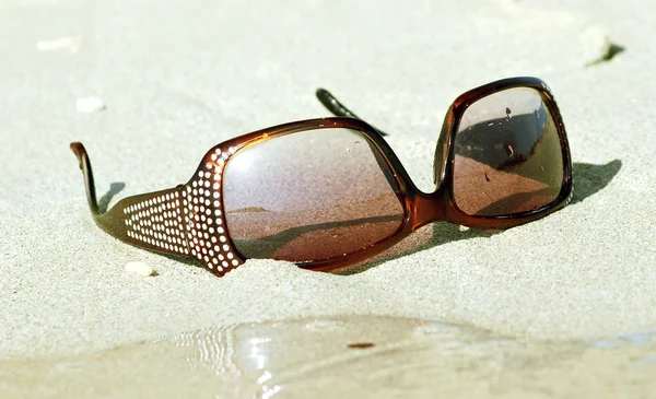 Mode-Sonnenbrille auf weißem Sand — Stockfoto